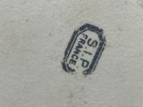an image of a close up of a white vase with a blue stamp on it