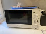 a microwave sitting on a counter top next to a window