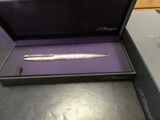 a silver pen in a purple box on a table