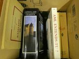 des livres dans une boîte en carton posée sur une table, à côté d'autres livres
