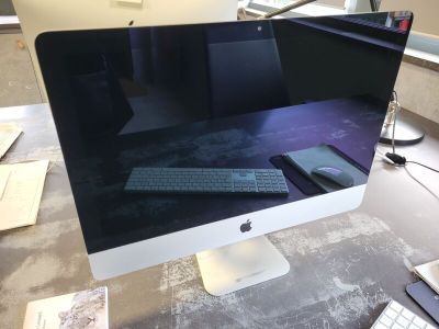a computer monitor sitting on a desk with a keyboard and mouse
