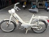 a white motorbike parked in a parking lot
