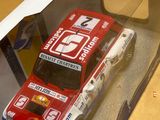 une voiture rouge et blanche dans une boîte posée sur une table