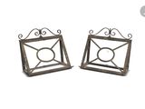 pair of metal candle holders with a circular design on each of them
