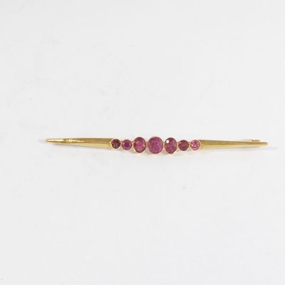 un gros plan sur un lingot d'or orné de trois pierres roses