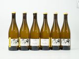 six bouteilles de vin sont alignées sur une surface blanche
