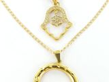 un collier en or orné d'une hamsa et d'un pendentif en diamant