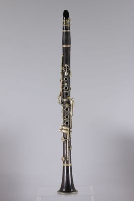 a close up of a clarinet on a clear surface with a gray background