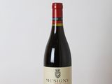 a bottle of red wine sitting on top of a wooden table