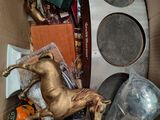 a cardboard box filled with assorted items and a horse statue