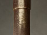 close up of a wooden cane with a leather handle on a gray background