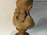 statue of a dog sitting on top of a wooden base