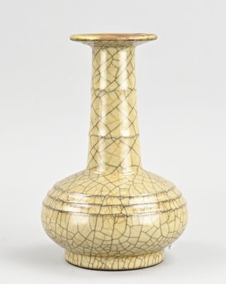 un vase jaune posé sur une surface blanche