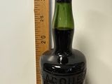 une bouteille d'alcool posée sur une table à côté d'une règle