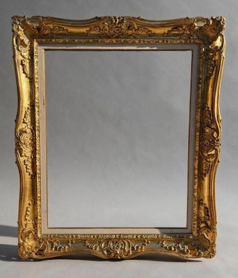 un miroir à cadre doré posé sur une table blanche