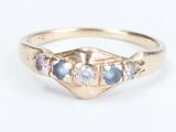 a close up of a gold ring with blue and white stones