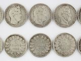 six different types of silver coins on a white surface