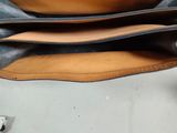 the inside of a black and brown purse with two zippers