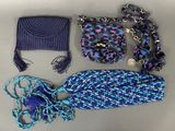 purple and blue handbag, scarf, hat, and purse laid out on a table
