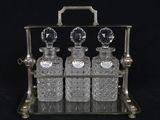 three glass bottles sitting on a metal stand