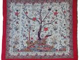 une couette rouge et blanche ornée d'un arbre et de fleurs