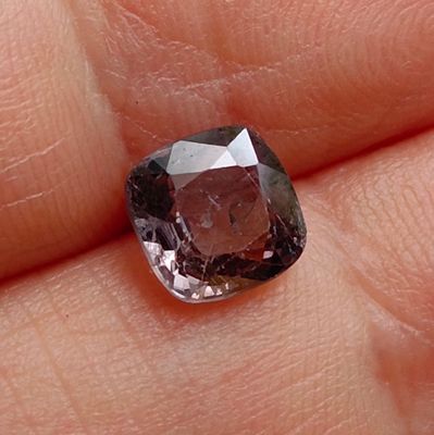 a close up of a person ' s hand holding a brown and white diamond