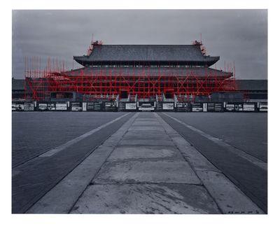 un échafaudage rouge sur le côté d'un immeuble, sur une photo en noir et blanc
