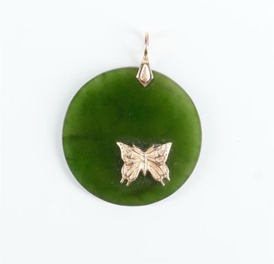 une image représentant un pendentif vert orné d'un papillon