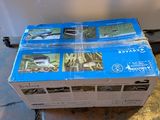a stack of boxes sitting on the floor in front of a refrigerator