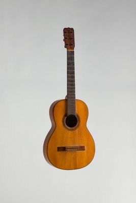 une vieille guitare en bois accrochée au mur