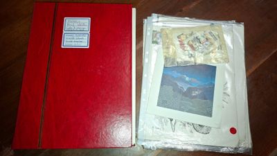 un livre rouge avec une illustration sur la couverture, posé sur une table