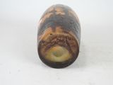 a brown and black vase sitting on a white surface