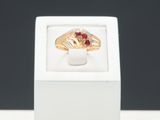 Gros plan sur une bague en or ornée d'une pierre rouge