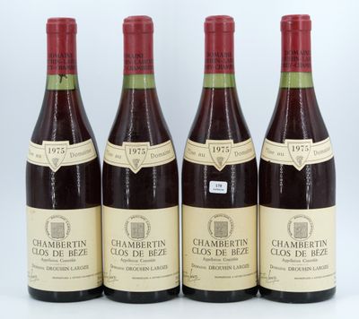four bottles of wine are lined up on a white surface