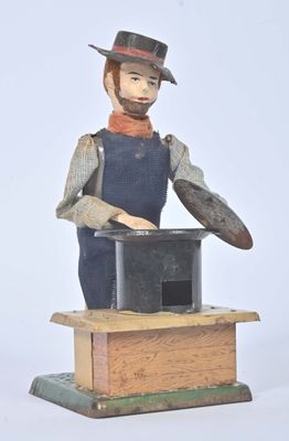 une figurine représentant un homme coiffé d'un chapeau, posée sur une boîte
