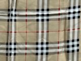 a close up view of a tan plaid shirt with black, red, and white squares