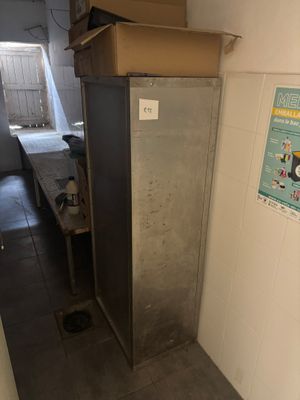 un réfrigérateur dans un coin d'une pièce, avec une boîte posée dessus