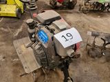 Plusieurs tondeuses à gazon sont garées dans un garage, avec une plaque d'immatriculation à l'avant.