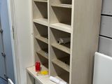 a cabinet with a drawer and a trash can in the corner