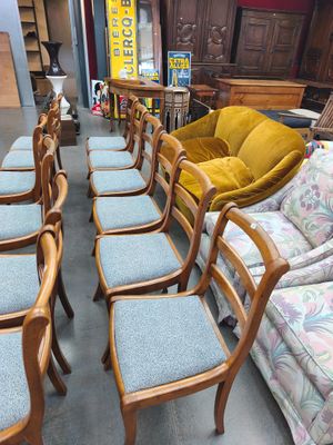 de nombreuses chaises et canapés dans une pièce très meublée