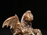 bronze figurine of a winged child on a black background