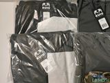 three pairs of men ' s black and white shirts are wrapped in plastic