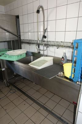 une cuisine équipée d'un évier et d'un lave-linge