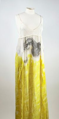 une photo d'une robe jaune et blanche posée sur un présentoir pour mannequin