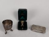 a small silver box with a ring inside of it and a small silver box with a ring inside of it on a white surface