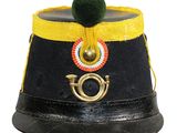 un chapeau noir orné d'un ruban jaune et d'un pompon vert