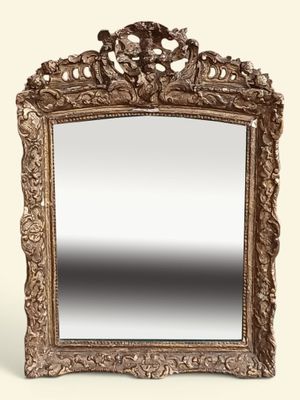 On voit un miroir richement sculpté sur fond blanc.