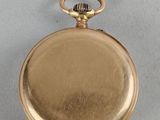 an old gold pocket watch with a chain hanging from it ' s side