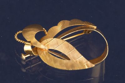 gros plan d'un bracelet en or sur une surface noire