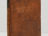 an old book sitting on top of a table next to a white wall